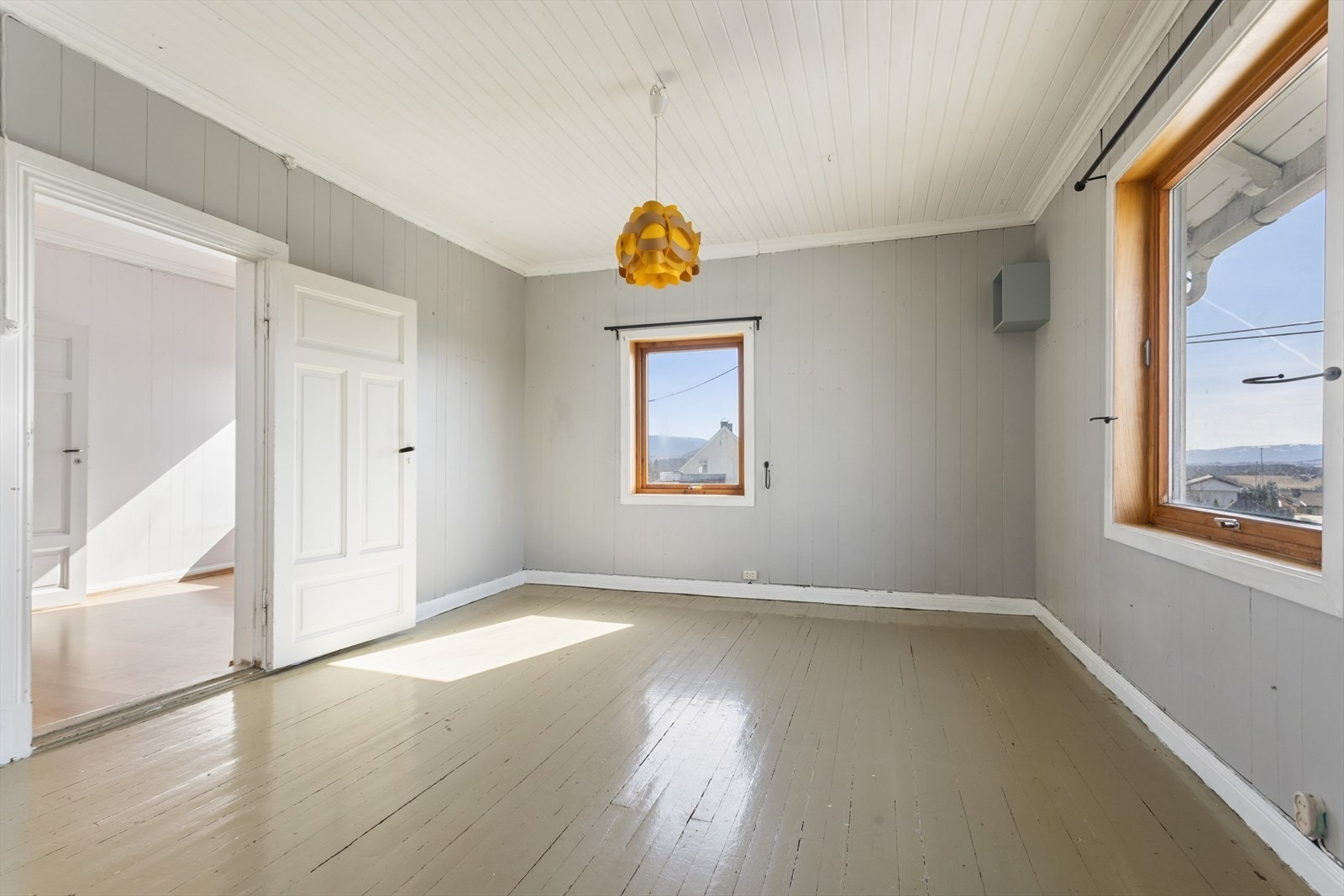 Et av tre soverom i etasjen, alle med varierende overflater av panel og tregulv. Galleribilde