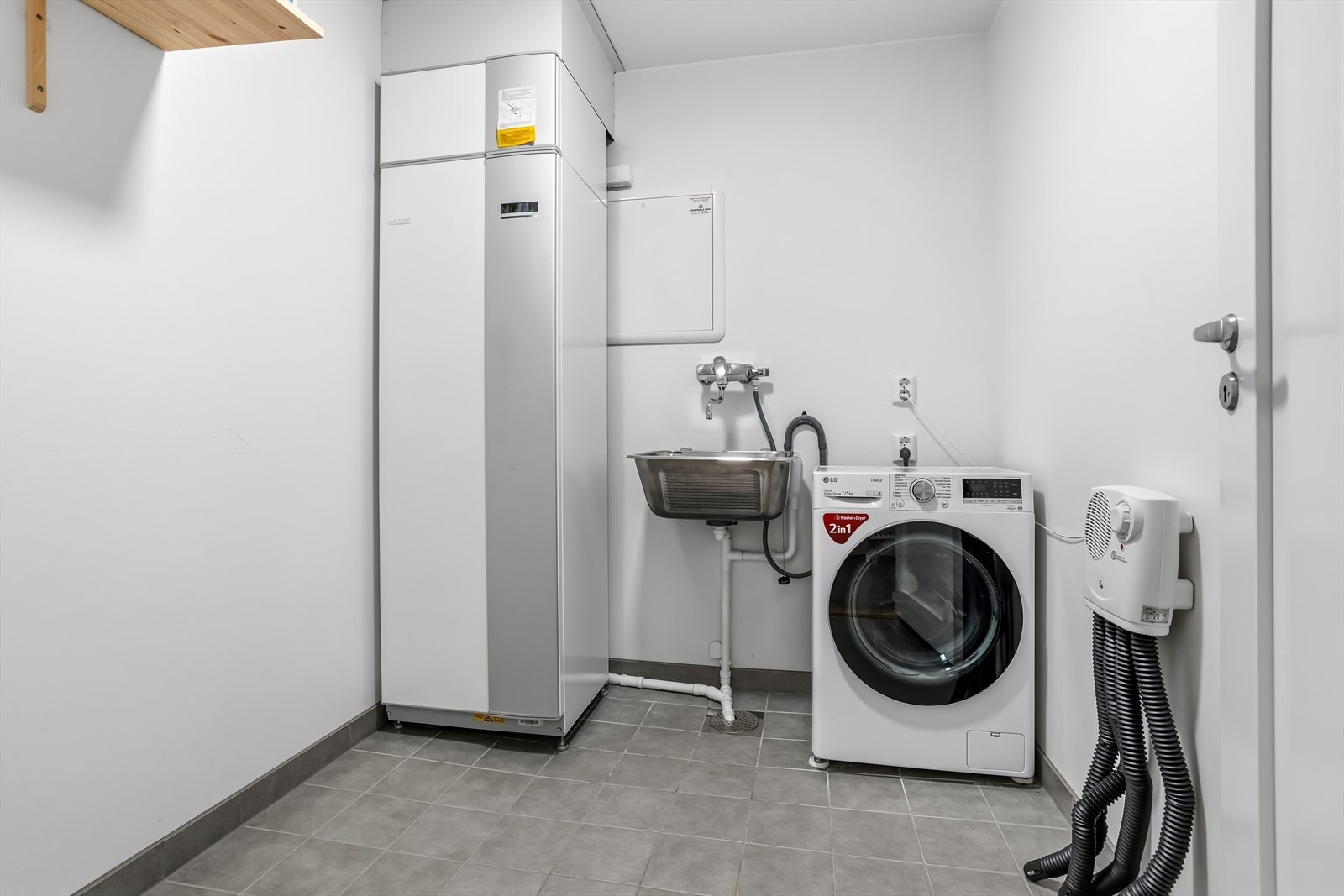 Vaskerom med elektriske varmekabler, skyllekar i stål og opplegg for vaskemaskin. Galleribilde