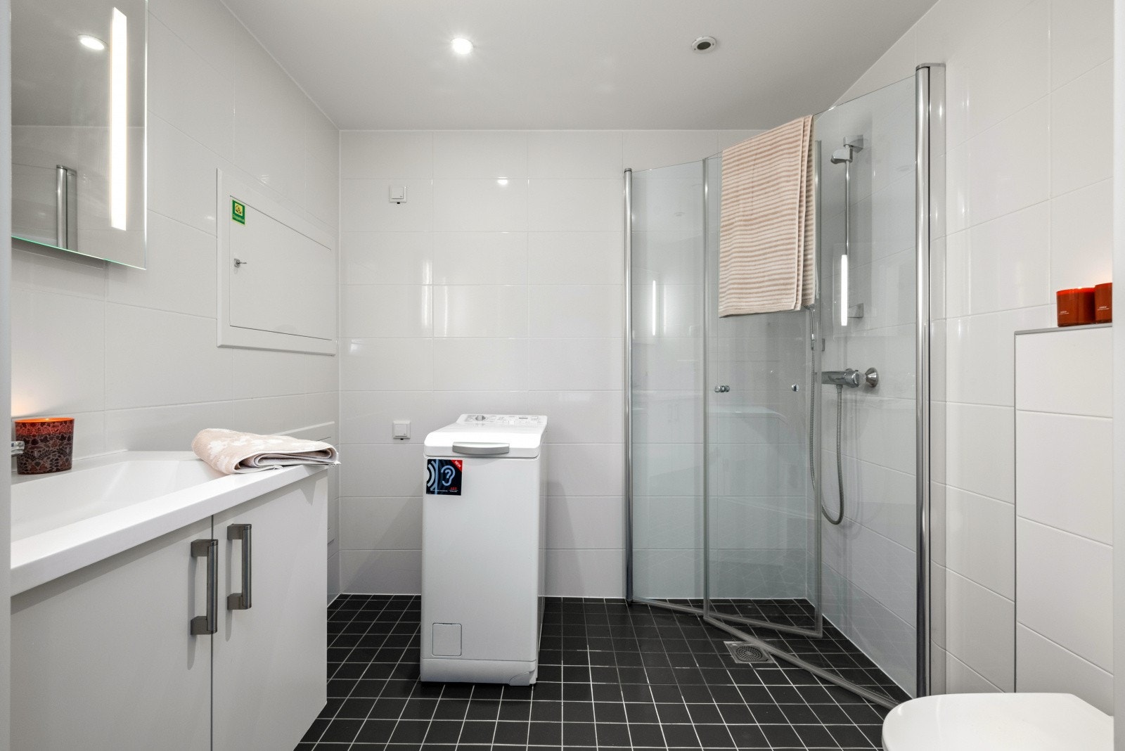 Dagene får en god start på badet, lekkert innredet med hvite og sorte fliser for en fin kontrast. Det er spotter i taket. Galleribilde