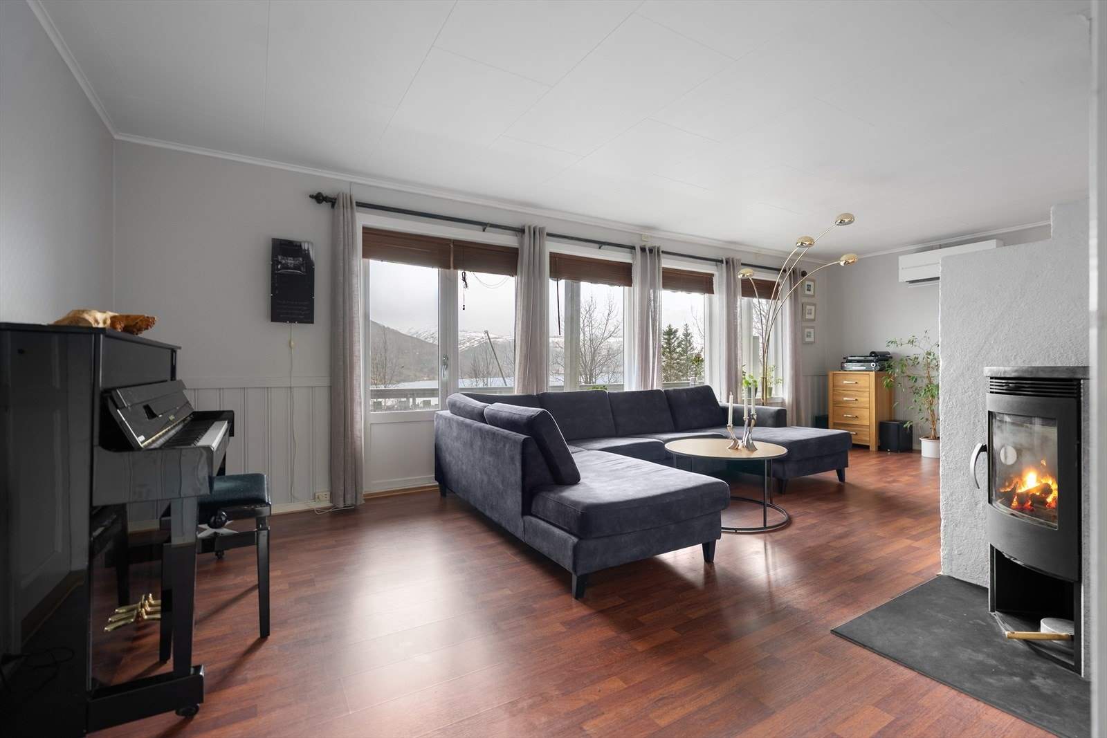 Velkommen inn! Romslig stue med god plass for stuemøbler og peis som gir en lun og god varme på kalde dager. Fra stuen har du direkte adkomst til veranda. Galleribilde