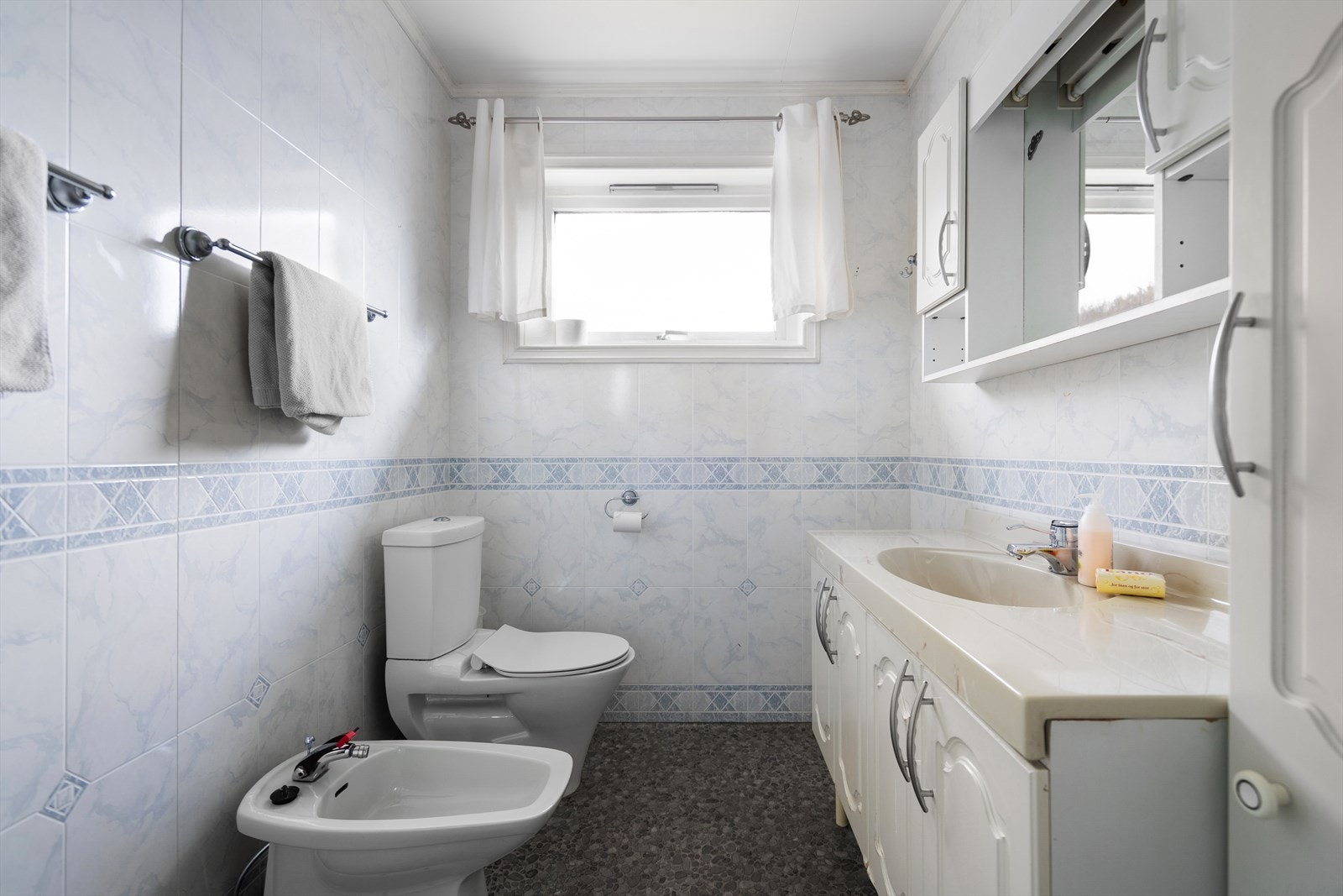 Badet inneholder toalett, bide, innredning med 2 nedfelte servanter og dusjkabinett. Galleribilde