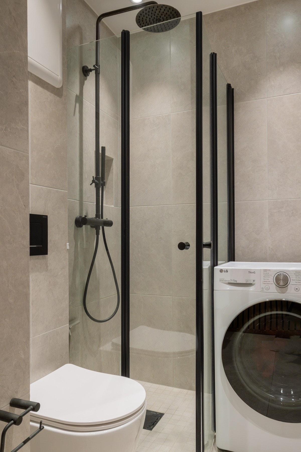 Badet har dusjhjørne med regnfallsdusj og håndholdt dusj, vegghengt toalett og opplegg for vaskemaskin. Galleribilde