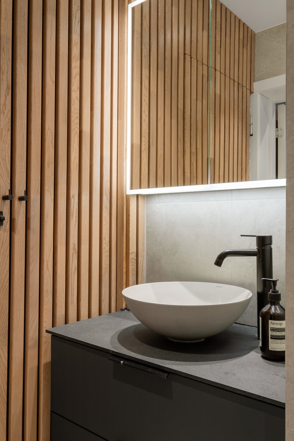 Badet har flere lekre detaljer som spilevegg og mørke armaturer. Galleribilde