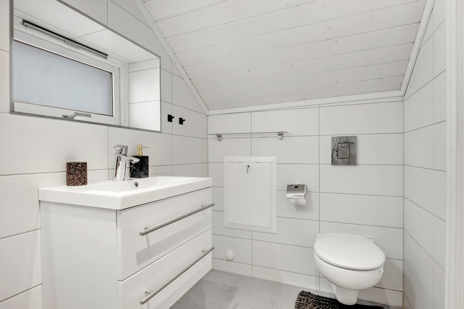 Baderom med flislagte overflater. Det er installert varmekabler i gulvet, spotlights i taket og speil med integrert belysning. Galleribilde