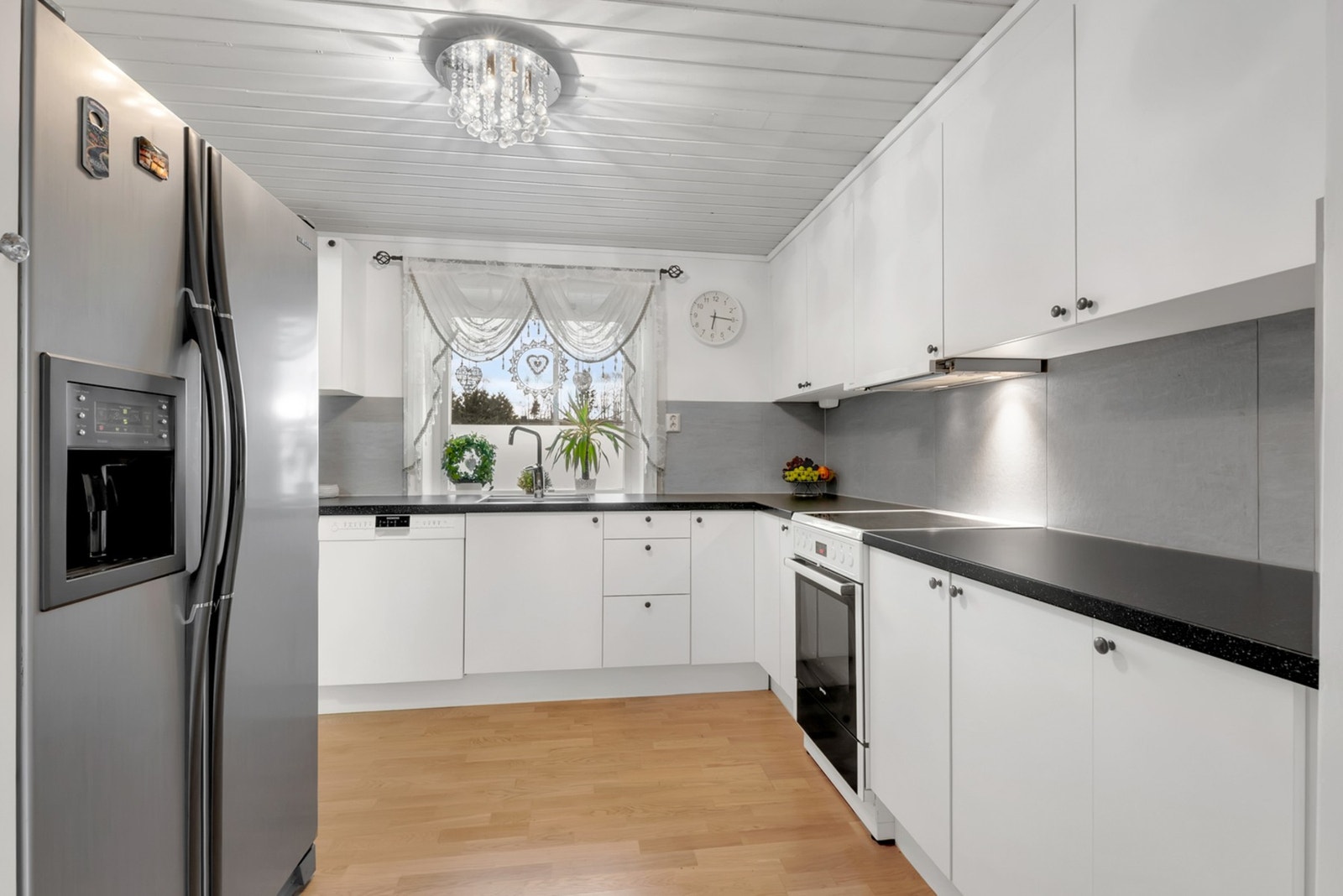 Pent kjøkken som er utført med slette fronter og laminert benkeplate. Galleribilde