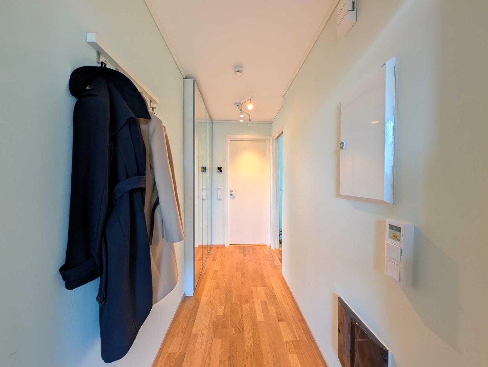 Entréen er på 4,6 kvm med trestavs parkett på gulv og slette malte vegger og tak. Her er det god plass til å henge fra seg yttertøy i den romslige garderoben med speilvegg. Galleribilde