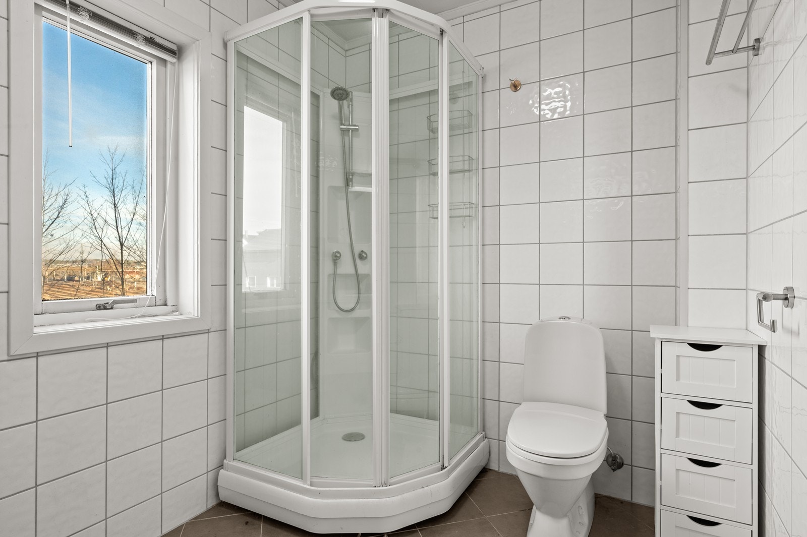 Badet er utstyrt med dusjkabinett, klosett og servant med tilhørende skap. Galleribilde