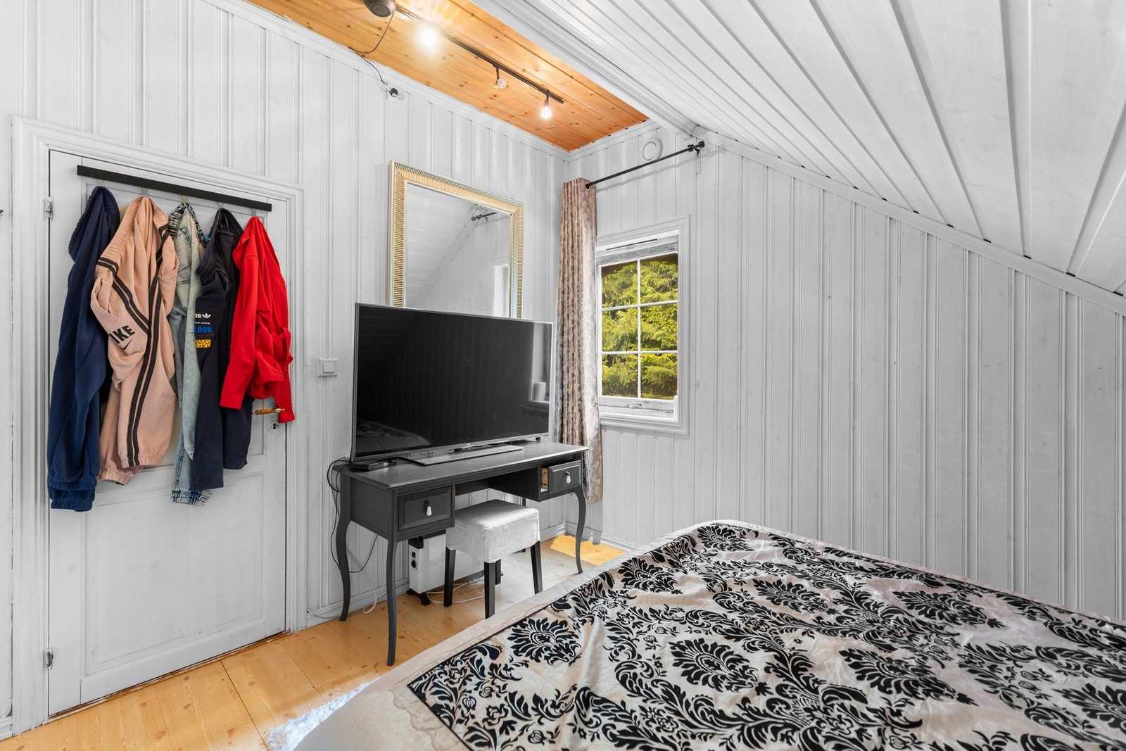 Soverom med praktisk innredning og naturlig lysinnslipp, med mulighet for både oppbevaring og TV-løsning. Galleribilde
