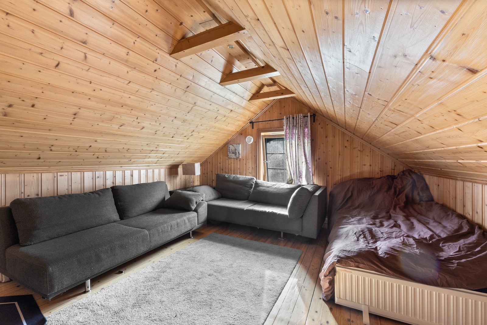 Sjarmerende rom med skråtak og lun atmosfære, med plass til både seng og sittegruppe. Galleribilde