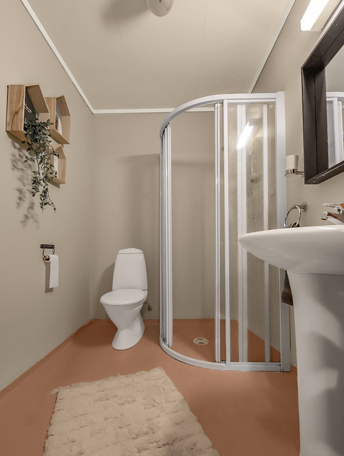 Bad i underetasje med belegg og varmekabler på gulv, våtromsplater på vegg. Badet inneholder servant m/skap, wc og dusjhjørne. Galleribilde