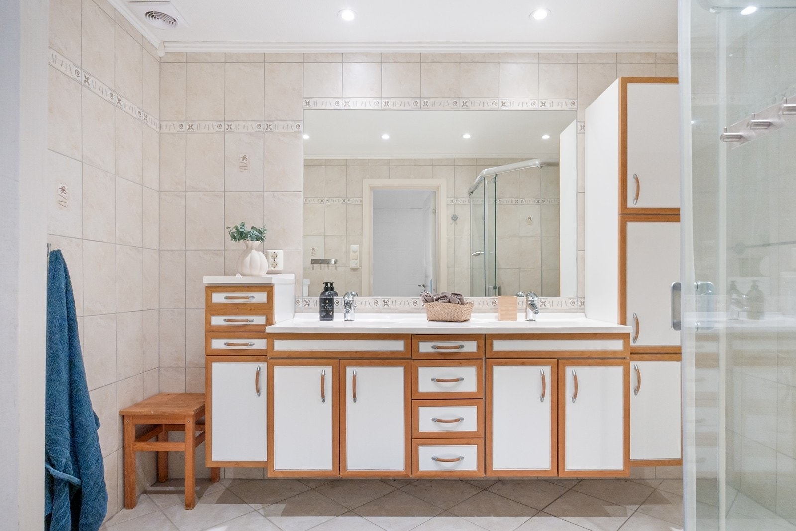 Badet har en bred baderomsinnredning med to nedfelte servanter, god skap- og skuffeplass, samt stort speil over Galleribilde