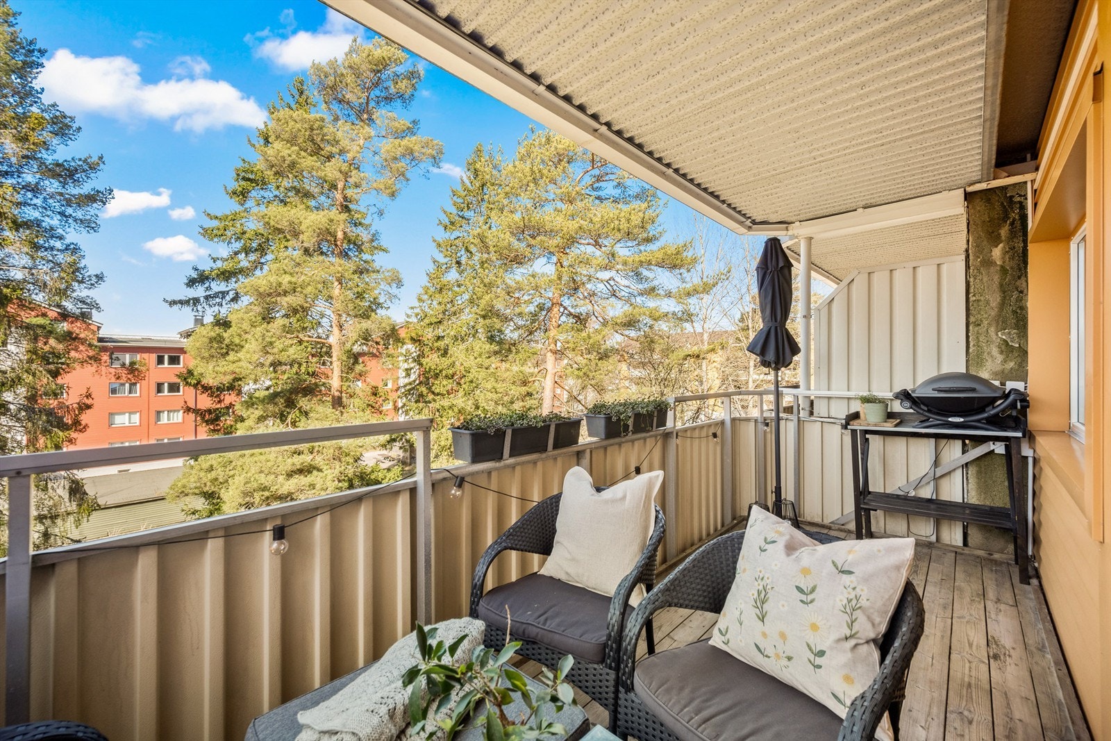 Balkongen er belagt med terrassebord og har et solid rekkverk i metall og fasadeplater. Galleribilde