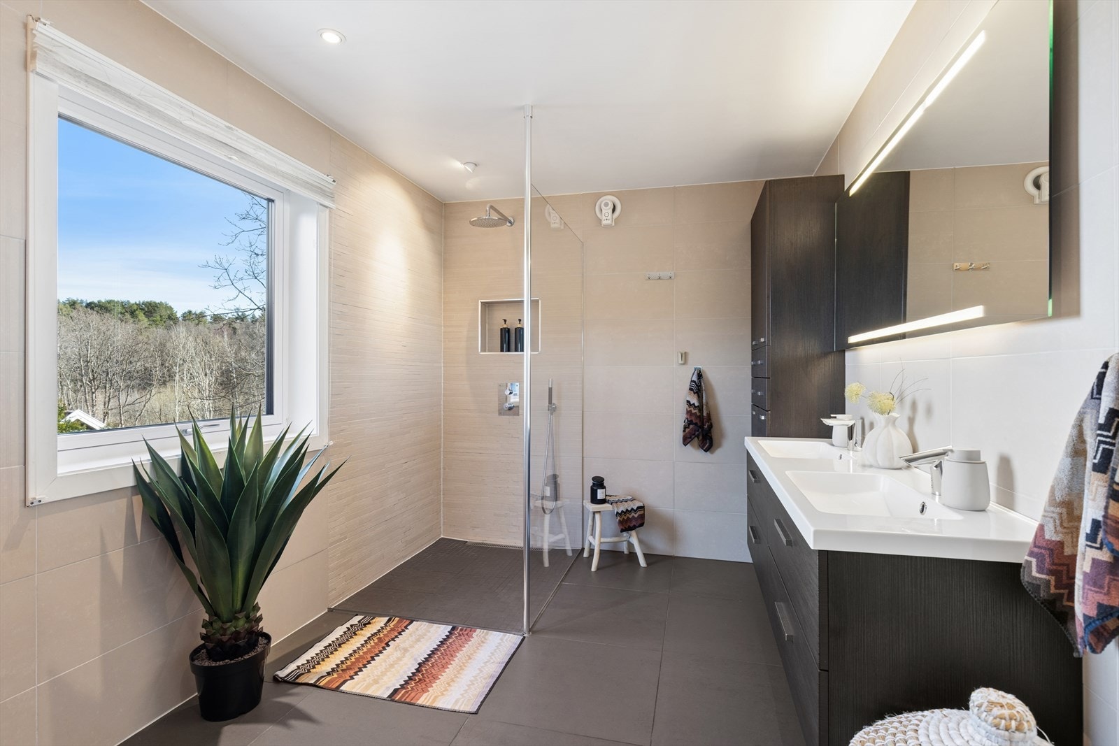 Badet i hovedetasjen er romslig, med dobbel servant, vegghengt toalett og en stor dusjsone med regnfallsdusj. Galleribilde