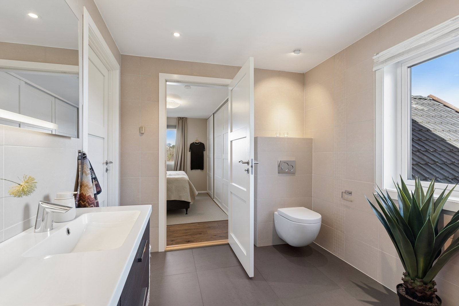 Fra badet i hovedetasjen er det direkte inngang til hovedsoverommet, som gir en praktisk en-suite-løsning. Galleribilde