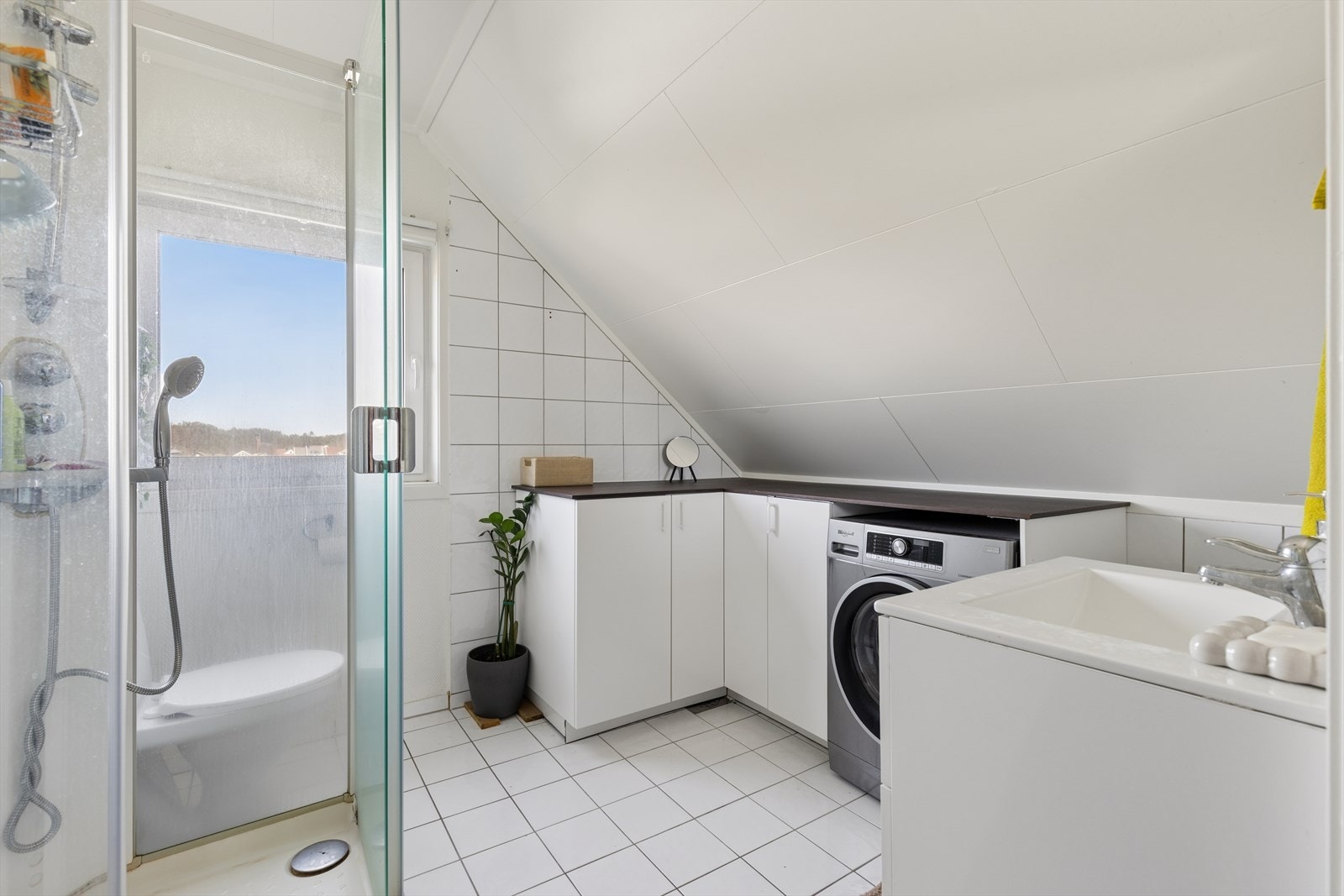 Badet i loftsetasjen er utstyrt med dusjkabinett, servant og opplegg for vaskemaskin. Galleribilde