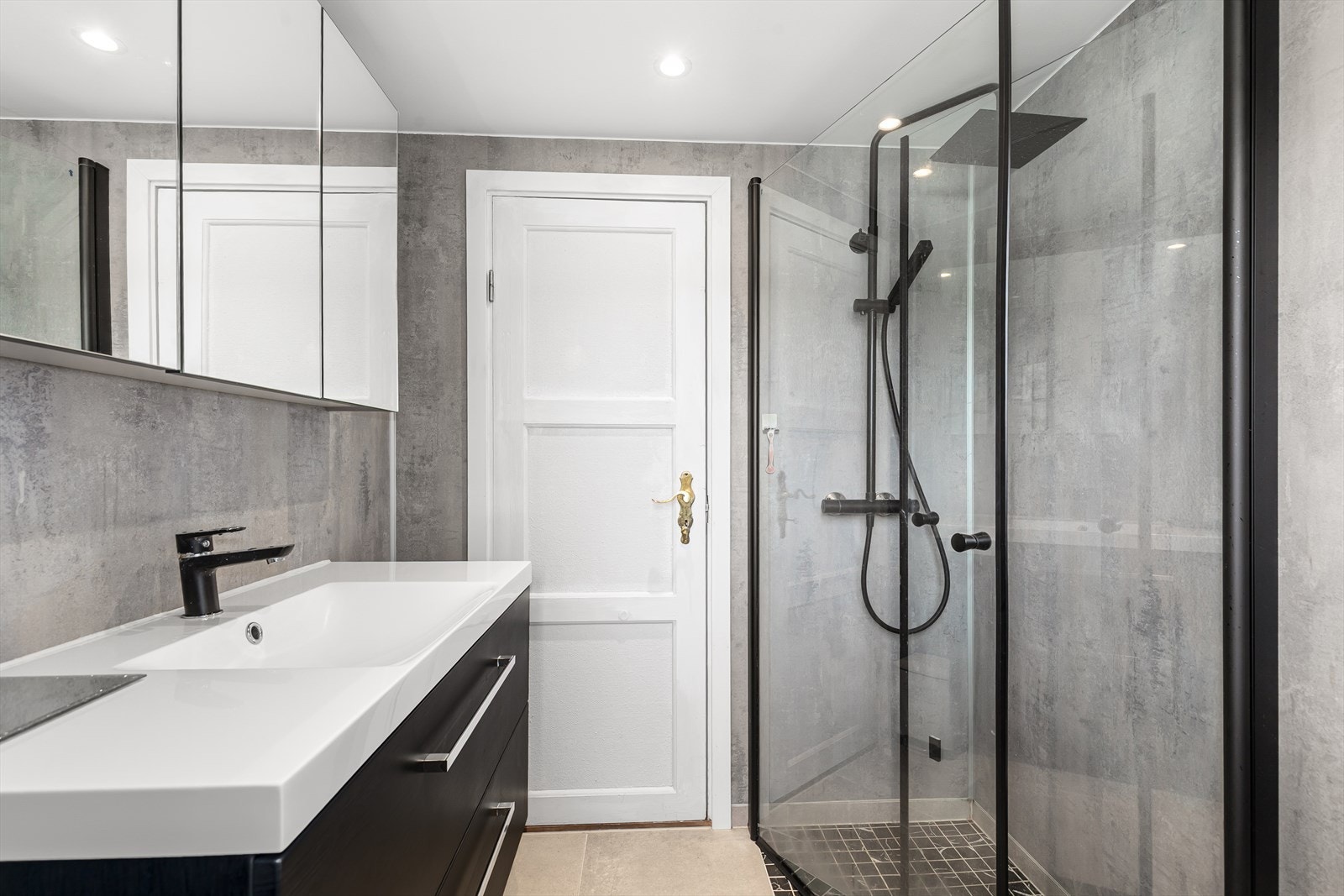 Badet har vegger av baderomsplater, og himlingen har av malte plater. Det er innredet nedfelt servant med skuffer og speil og spotter i taket. Dusjvegger/hjørne. Galleribilde