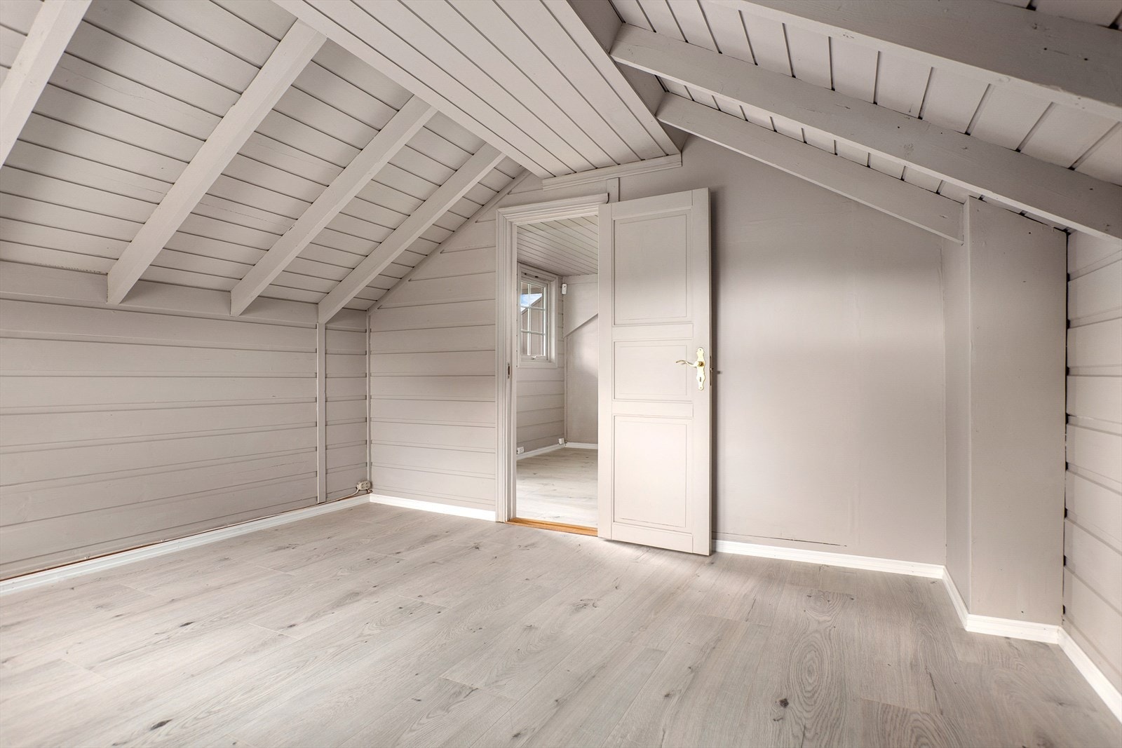 Det er laminat på gulv, malt trepanel både på vegger og tak. Galleribilde