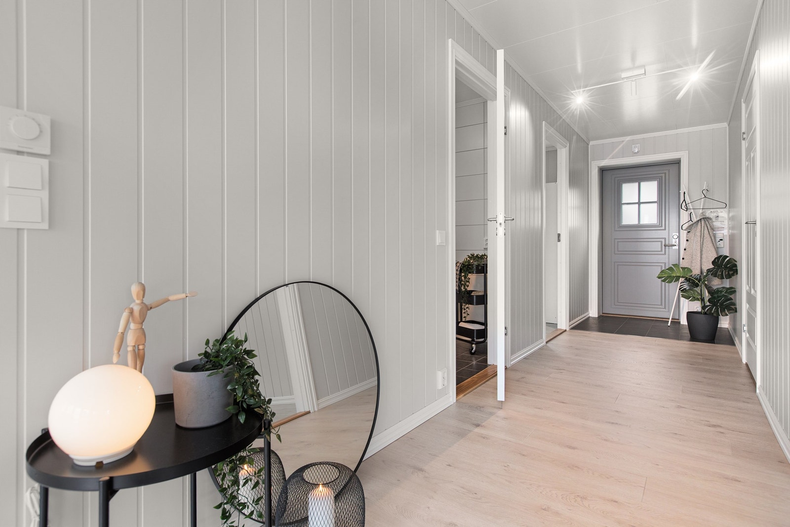 Gjennomgående materialvalg og malte panelplater på veggene og hvite, profilerte innerdører. Galleribilde