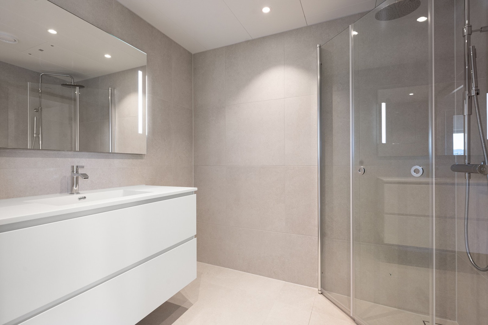 Badet er innredet med dusj, servant, speil og toalett. Galleribilde