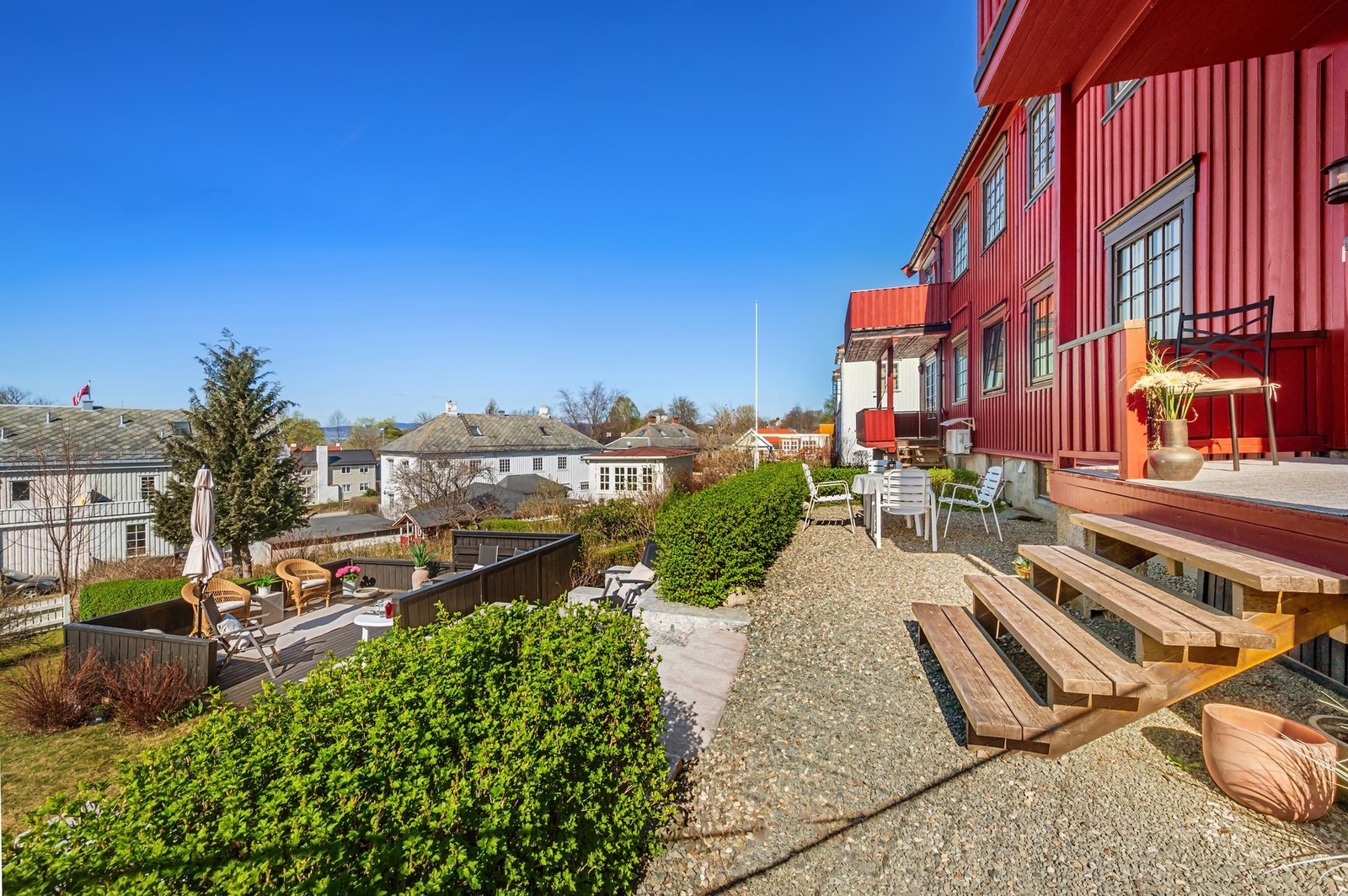 Uteplass i direkte tilknytning til boligen, med trapp opp til balkong og videre forbindelse til hagen. Galleribilde