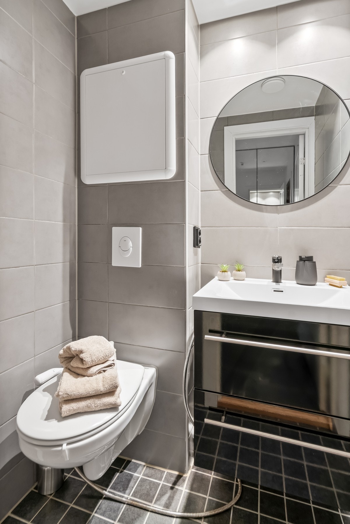 Det separate WC-et har en helhetlig innredning med benkeskap og glatte fronter, servant og speil, samt veggfestet klosett med innebygd sisterne. Galleribilde