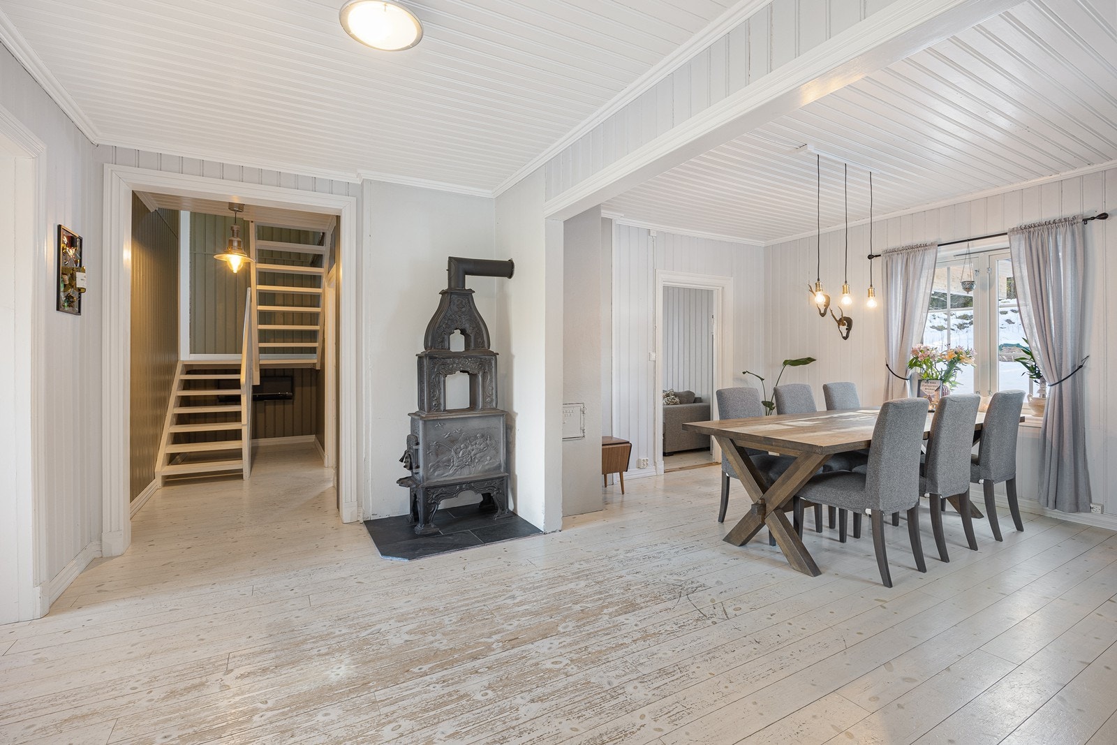 Tregulvet bidrar til en flytende overgang mellom sonene, og veggene er kledd med panel. Lune kvelder sikres av en fin, klassisk etasjeovn. Galleribilde