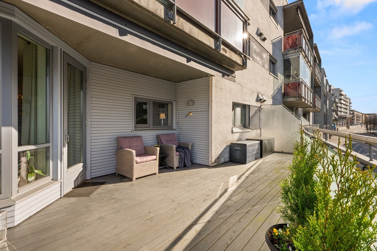 Balkonggulvet er lagt med terrassebord, og rekkverket i glass bidrar til en åpen og luftig følelse. Galleribilde