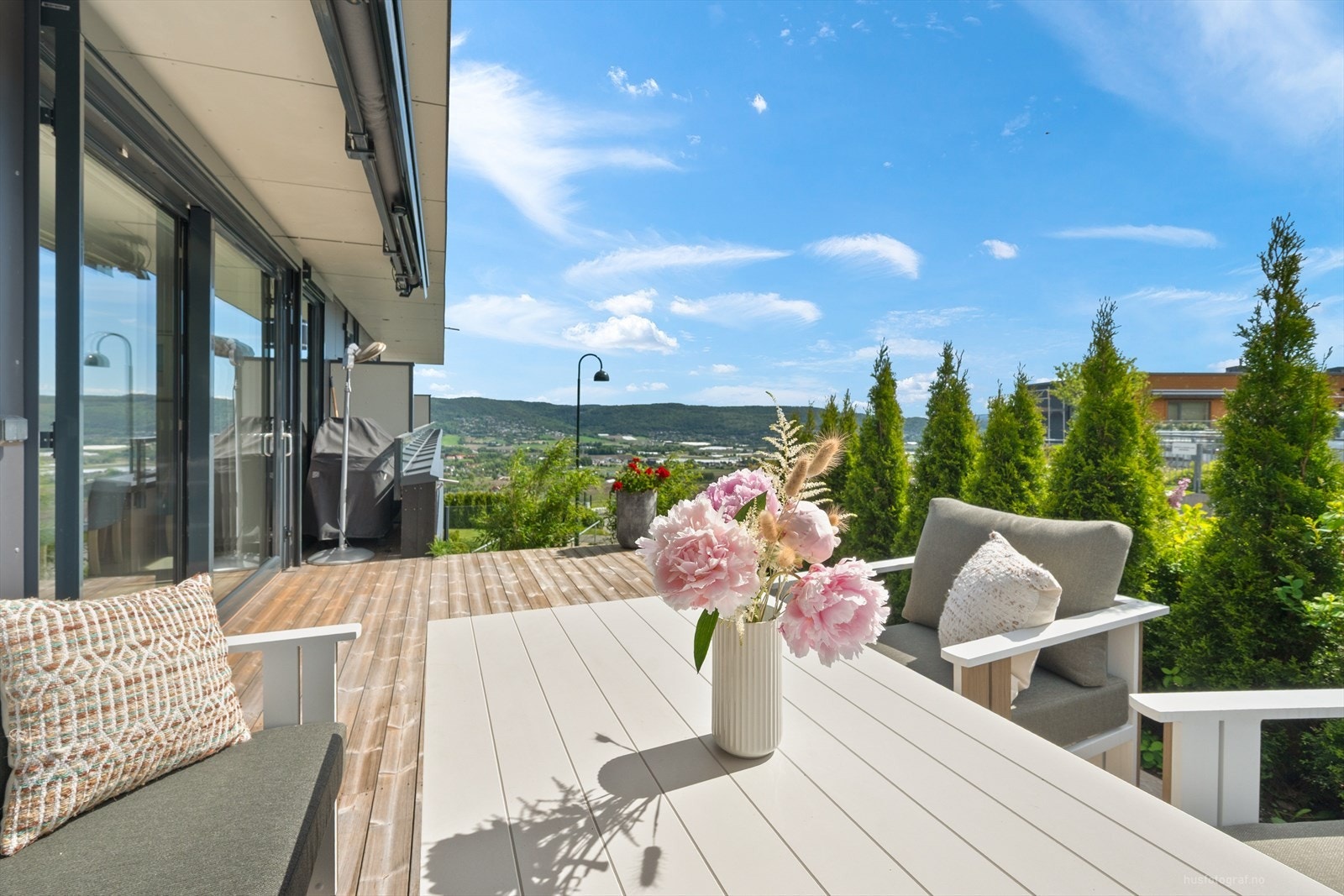 Solrik terrasse med tujaer som gir fin skjerming. Galleribilde