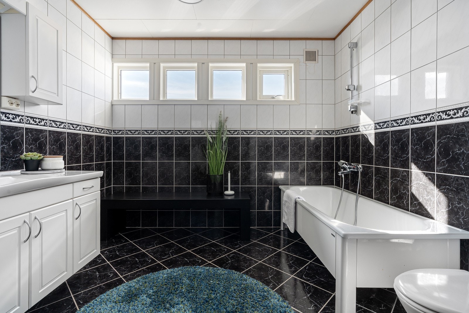 Her har man badekar, wc og baderomsinnredning med oppbevaringsplass.