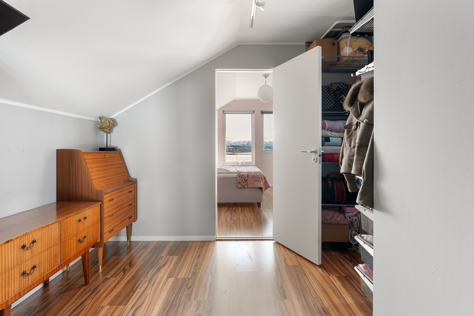 Mellomgang i loftsetasjen fungerer utmerket som oppbevaringsrom. Her er det også innredet med en praktisk garderobeløsning.