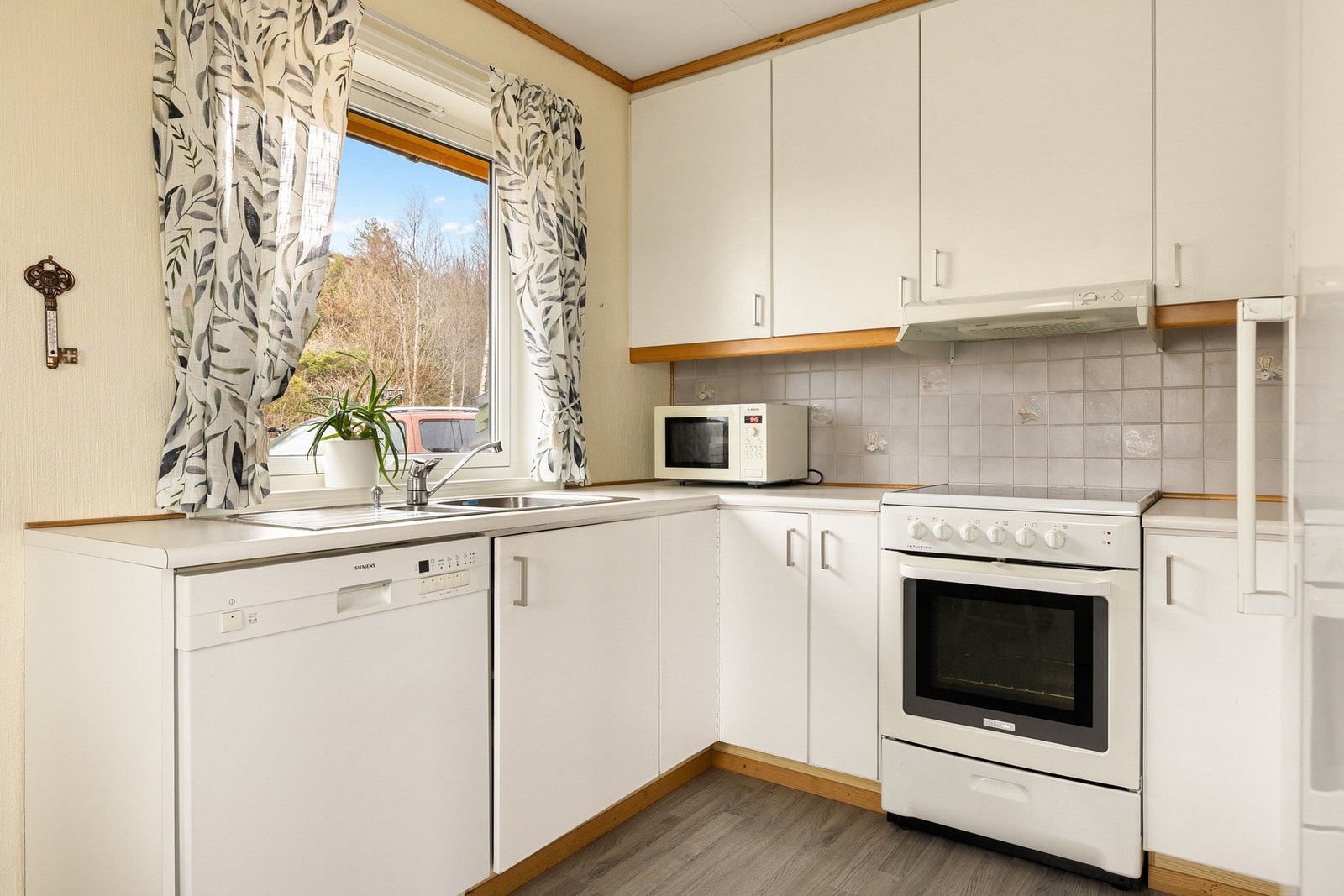 Kjøkkenet har en innredning som består av slette fronter og benkeplate av laminat. Galleribilde
