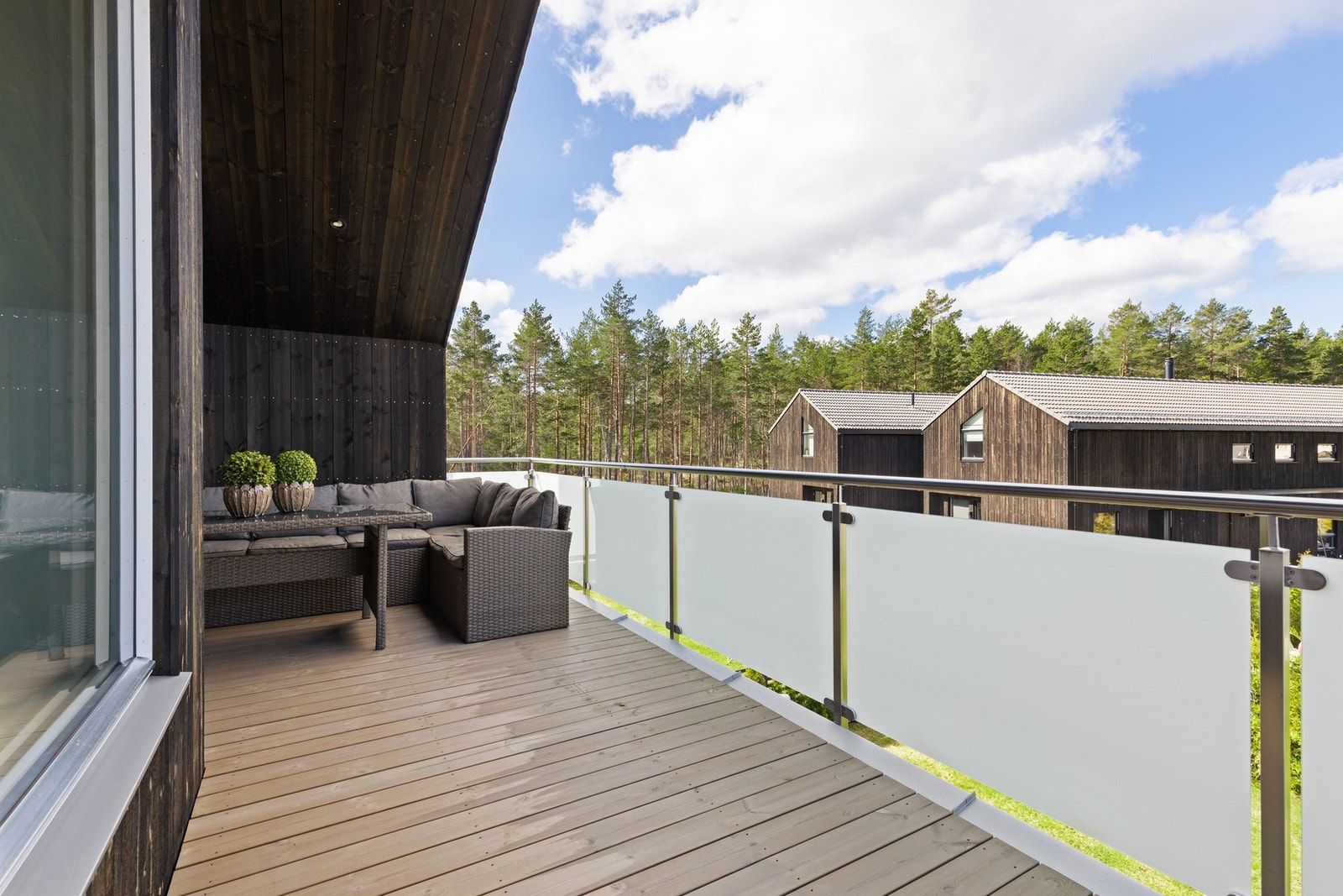 Uteplassen er oppført i trekonstruksjon med terrassebord og rekkverk i metall og glass Galleribilde