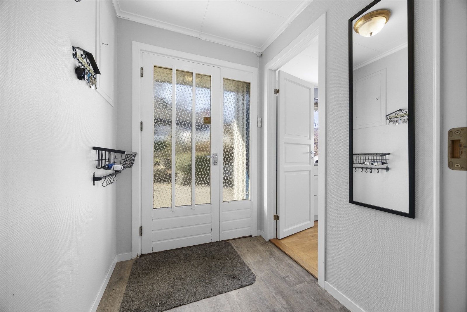 Vindfanget ønsker velkommen inn i boligens hovedetasje. Innerdøren med glassfelt gir et fint lysinnslipp til gangen. Galleribilde