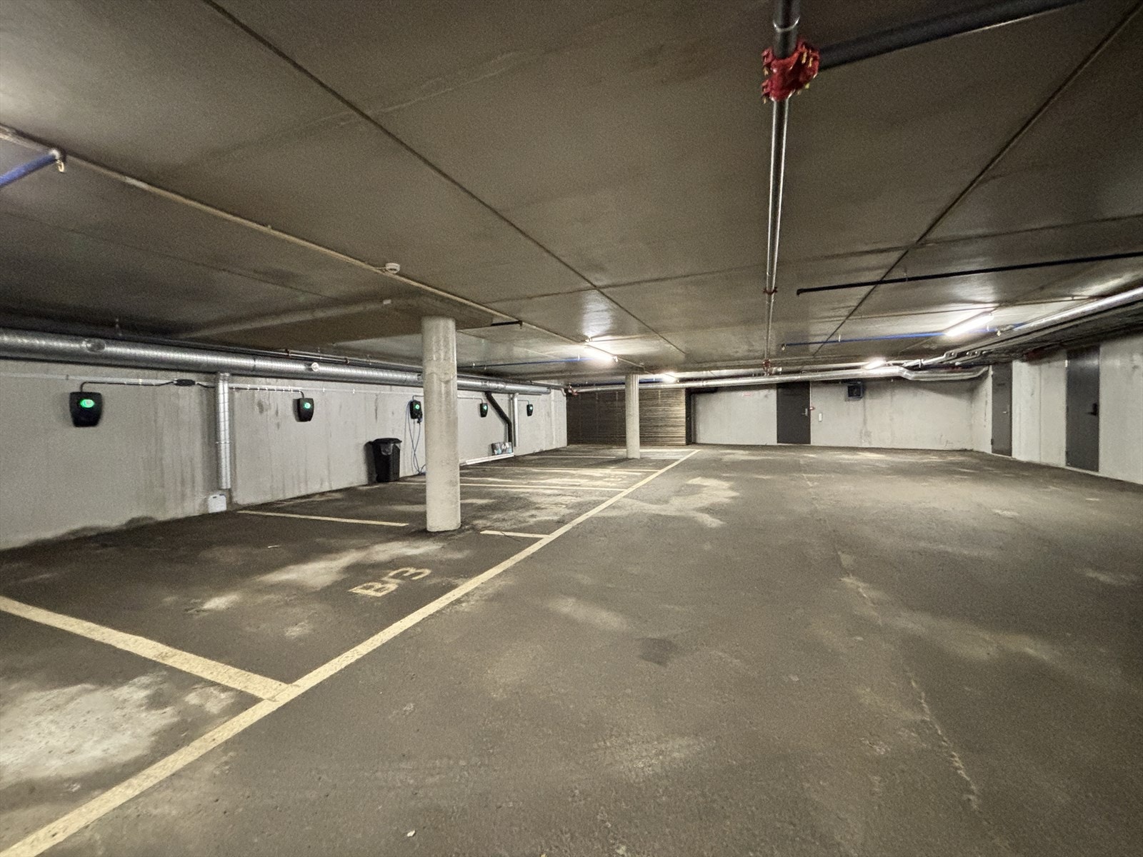 Parkeringsplass i garasjekjeller med elbillader. Galleribilde