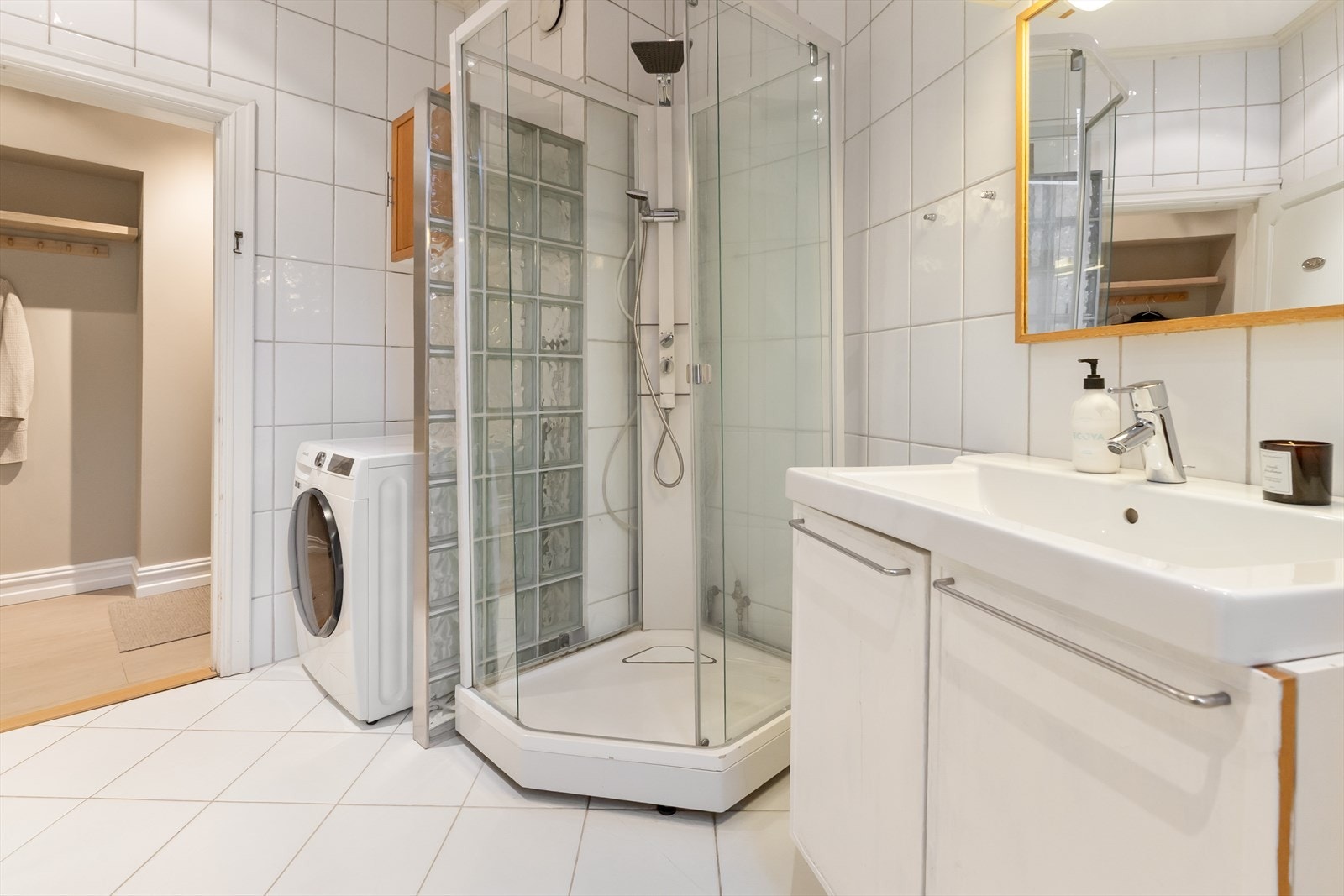 Badet inneholder dusjkabinett og baderomsinnredning med skap, servant med ettgrepsblandebatteri fra Hansgrohe og speil. Galleribilde