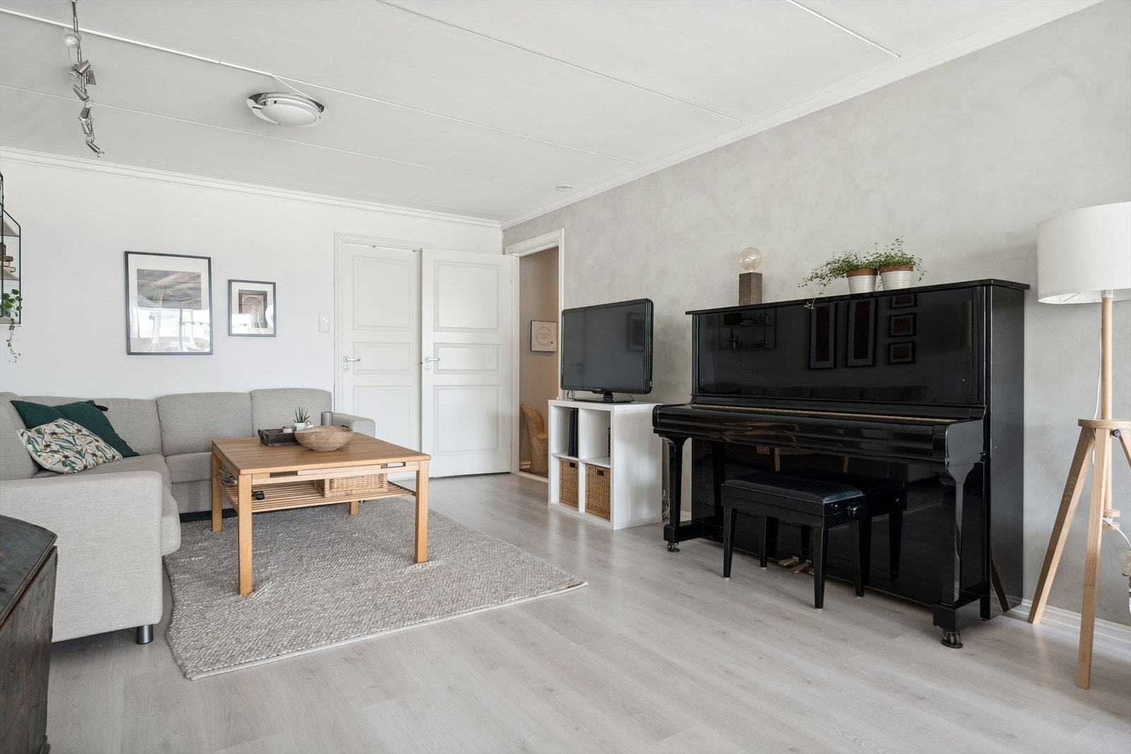 Stuen har laminat på gulv og vegger med malt tapet og malt betong, som gir et lyst og helhetlig preg. Galleribilde