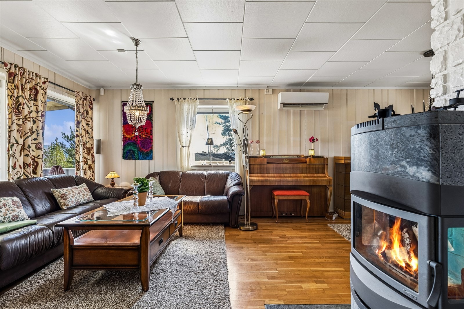 Denne stuen inneholder en peisovn med klebersteinskapper og en luft-til-luft-varmepumpe for effektiv oppvarming. Galleribilde