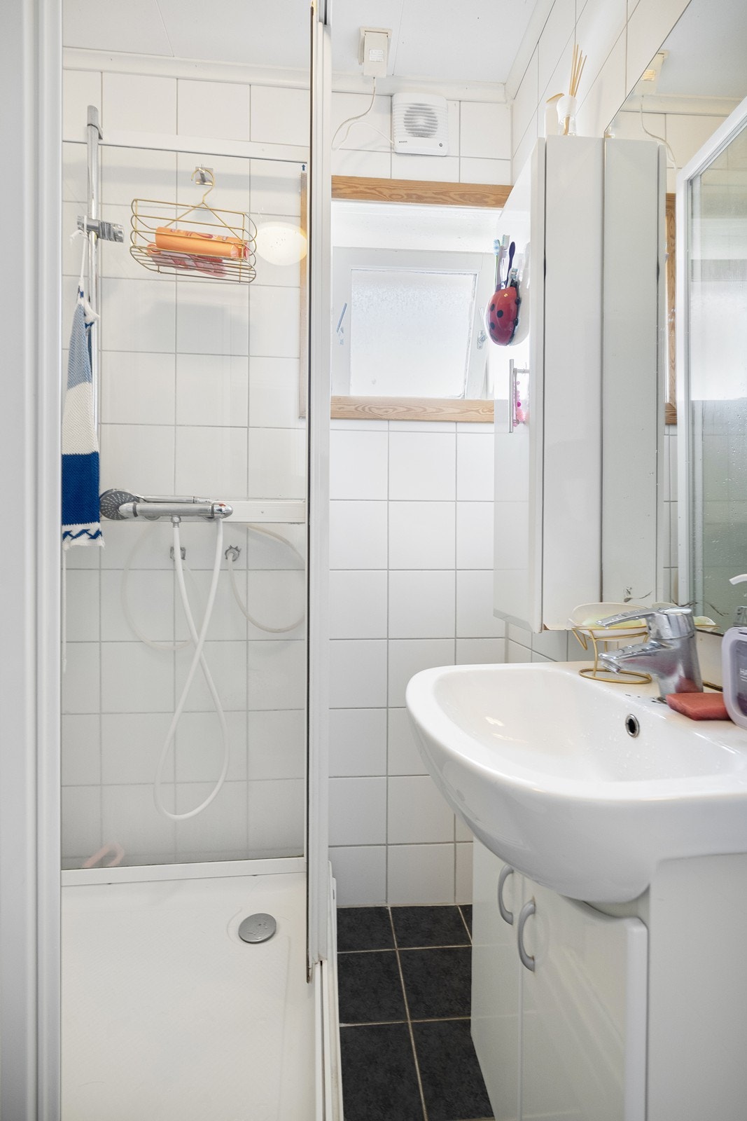 Helfliset bad med dusjkabinett, baderomsmøbel og toalett. Galleribilde