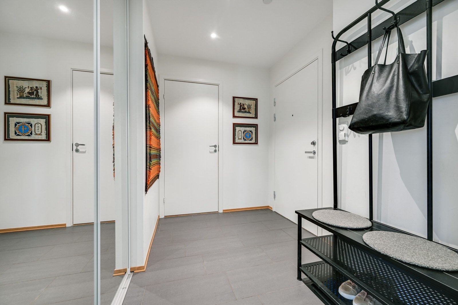 Velkommen inn i en lys entré med skyvedørsgarderobe og god plass til klesoppheng Galleribilde