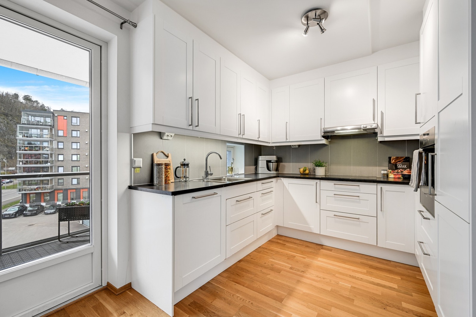 Det er kort vei til det delikate kjøkkenet med lyse fronter og en mørk laminert benkeplate. Det er stor arbeidsflate og godt med skap og skuffer for oppbevaring Galleribilde