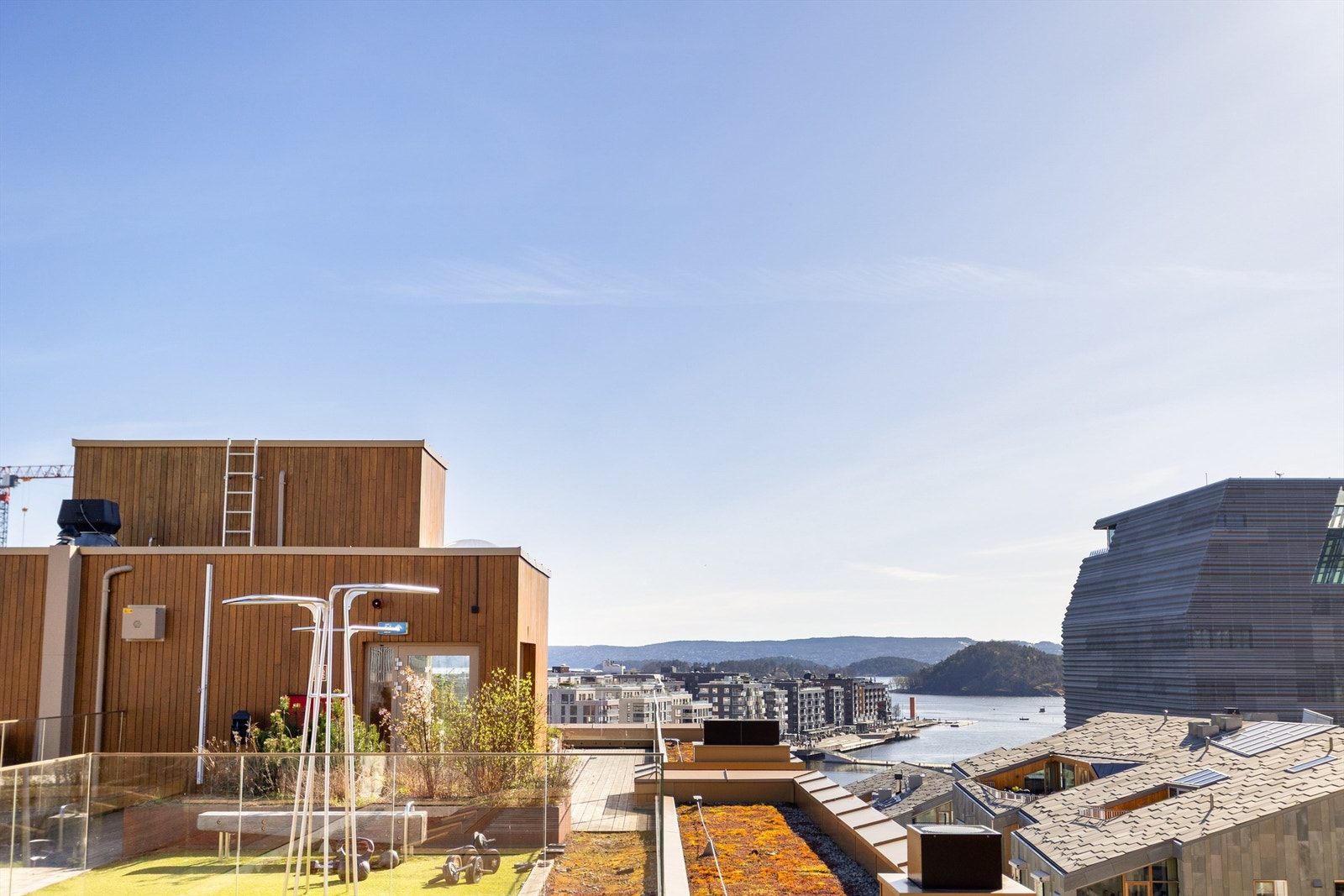 Takterrassen er pent opparbeidet med tredekke, beplantning og flere sittegrupper. Galleribilde