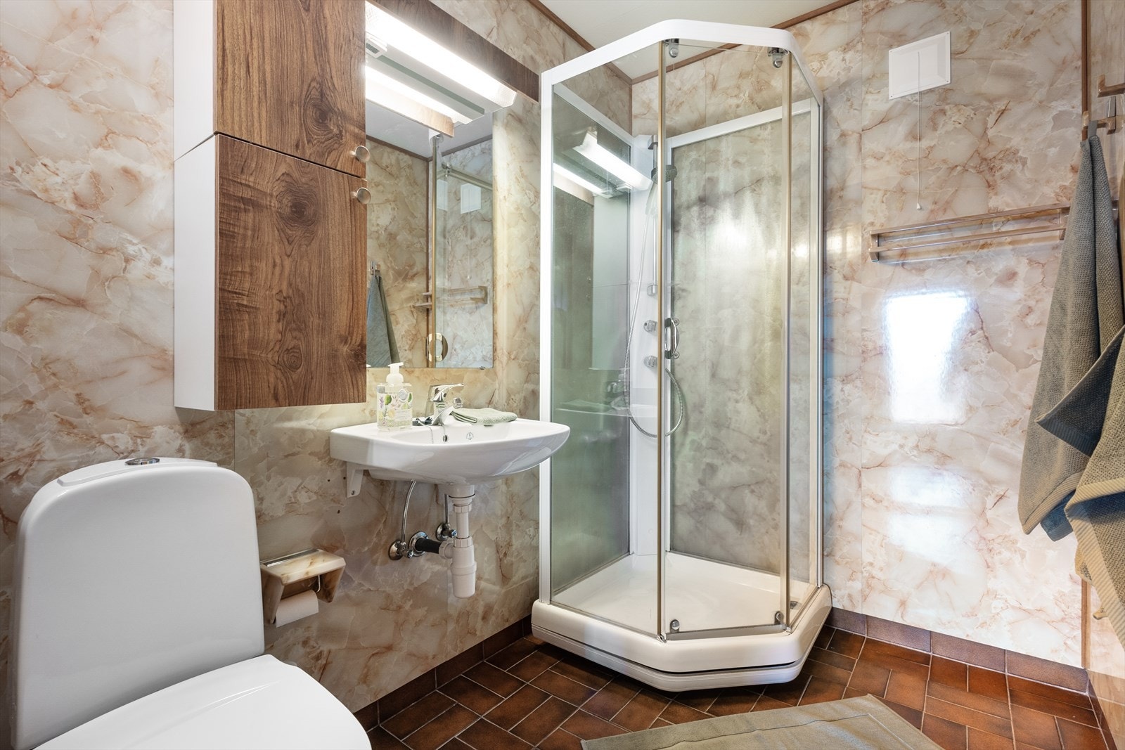 Badet i underetasjen har fliser på gulv og baderomsplater på veggene Galleribilde