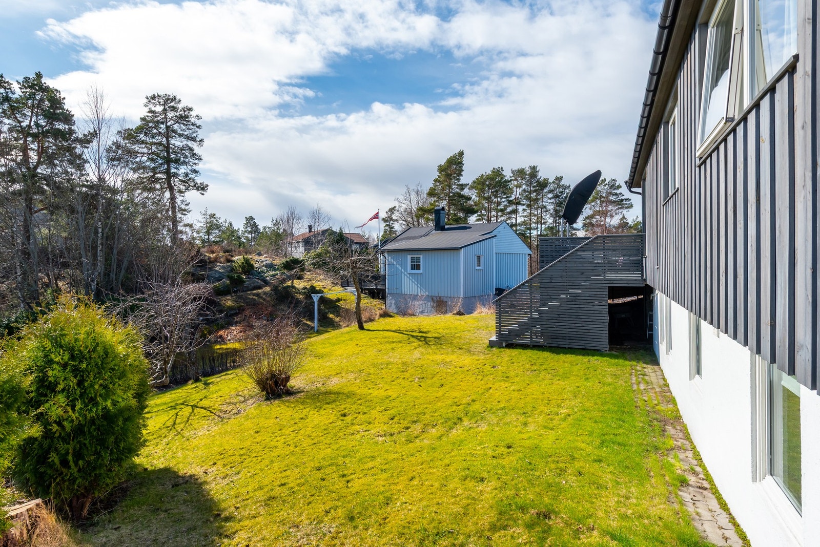 Velstelt hage med store grønne plenområder og god plass til familieliv ute. Galleribilde