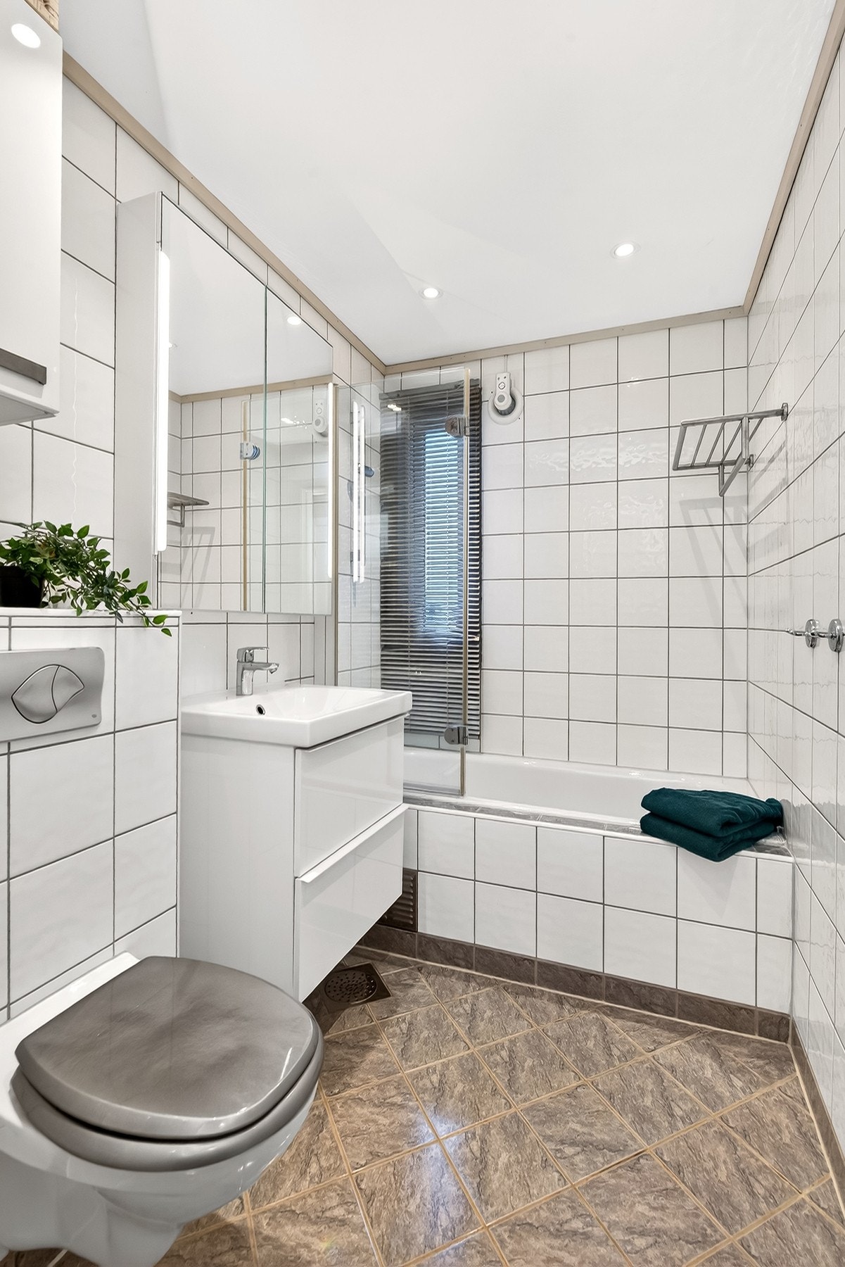 Bad med varmekabler, downlights, badekar, vegghengt wc og baderomsinnredning. Galleribilde