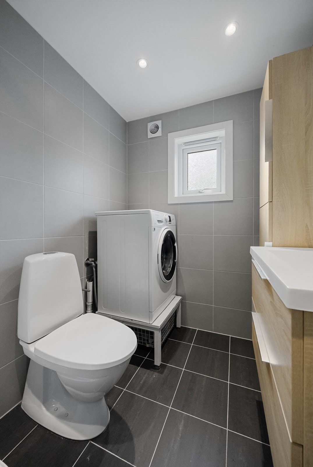 På badet er det vegghengt høyskap og speilflate på vegg. Galleribilde