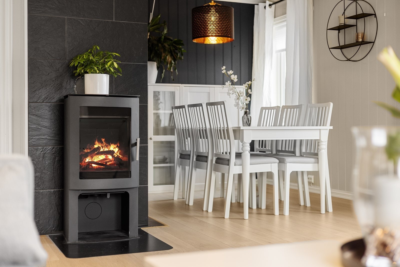 Sentralt i stuen er det en vedovn med glassflate som gir ekstra varme på kalde dager og skaper en lun og hyggelig atmosfære. Galleribilde