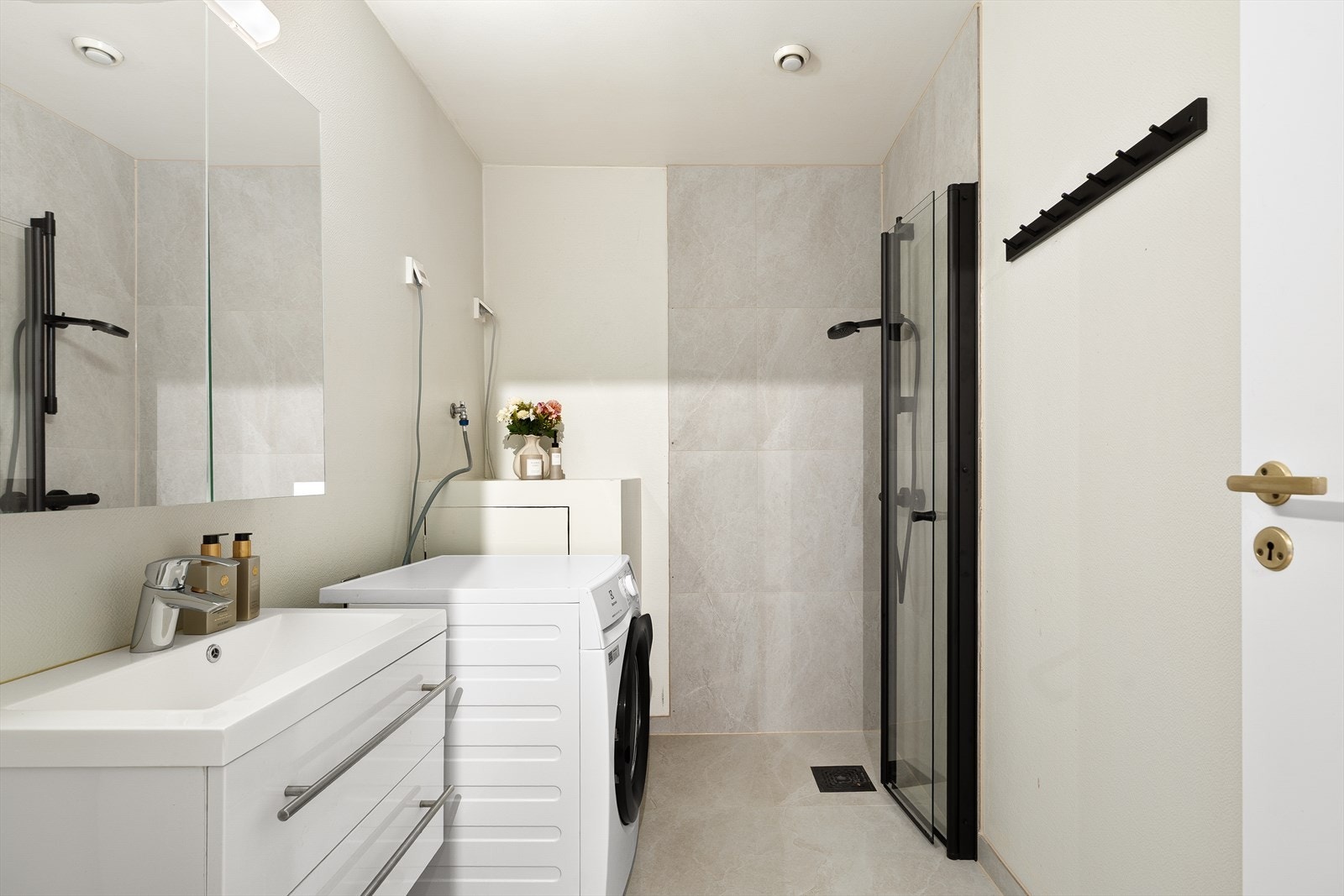 Påkostet bad med praktisk vaskeromsløsning og moderne innredning. Videre har badet gulvstående toalett, dusjhjørne, hel servant og god lagringsplass i speil og baderomsmøbel. Galleribilde