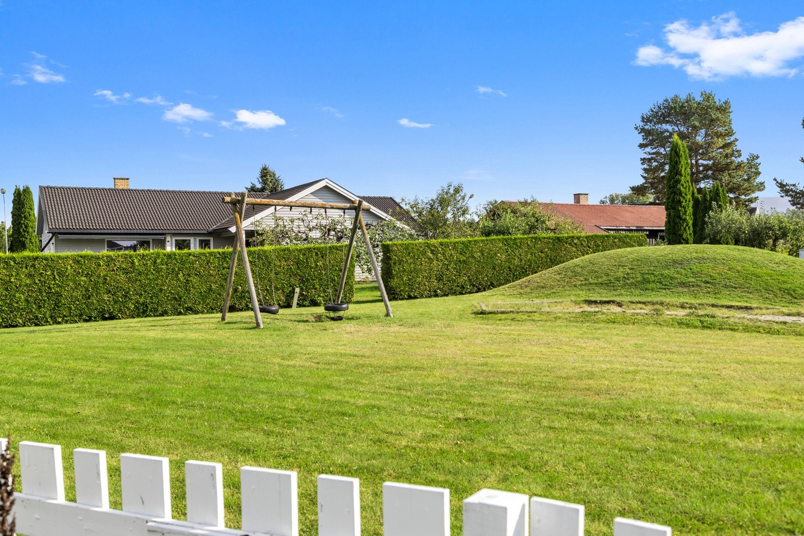 Grenser til lekeplass med grind i gjerdet. Perfekt for barnefamilien. Galleribilde
