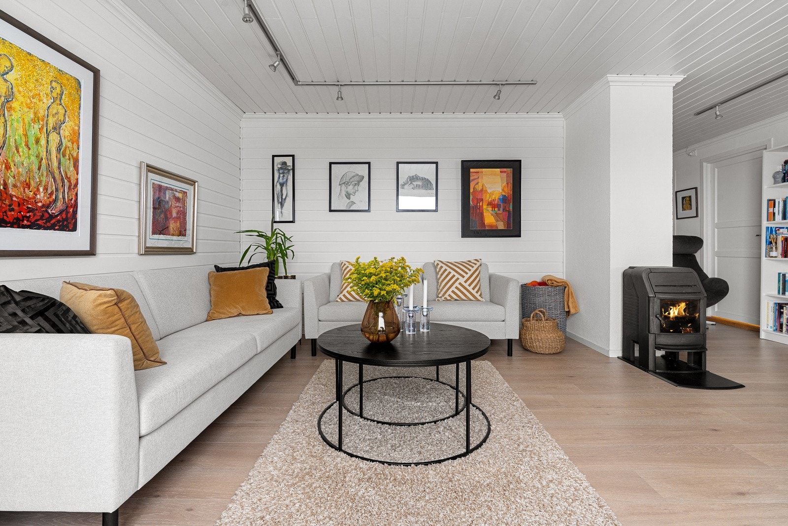 Lys og moderne stue med vedfyring.