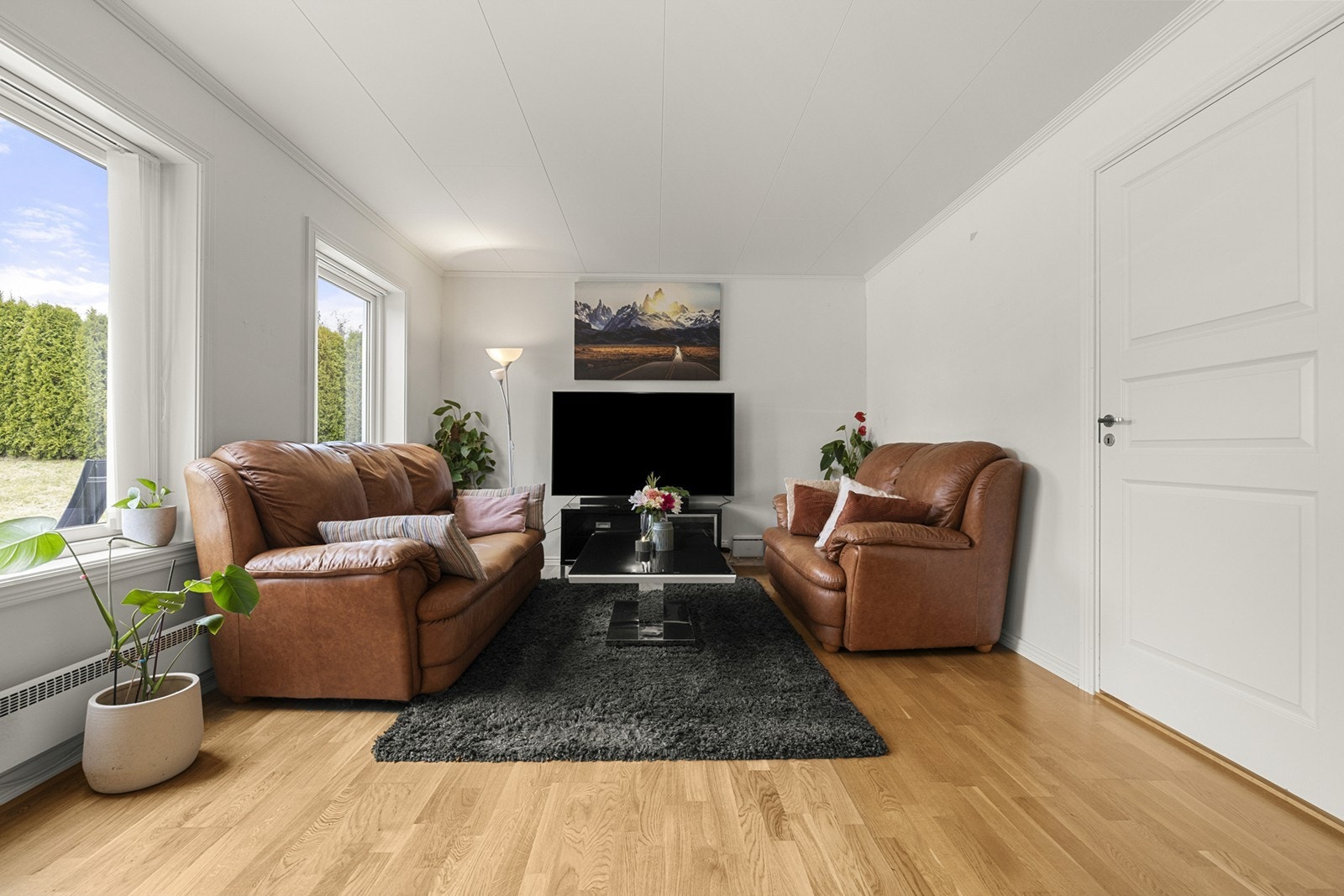 Store vindusflater gir godt naturlig lys i stuen. Galleribilde